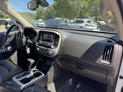 Interior of a 2018 Chevrolet Colorado pickup truck showing dashboard, steering wheel, center touchscreen, gear shifter, and front passenger area.