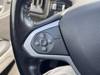 Steering wheel controls in a 2018 Chevrolet Colorado showing cruise control buttons and spray icon panel.
