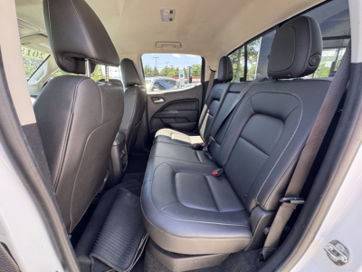 Chevrolet Colorado interior rear seat view showing black leather seats and three-row seating arrangement.