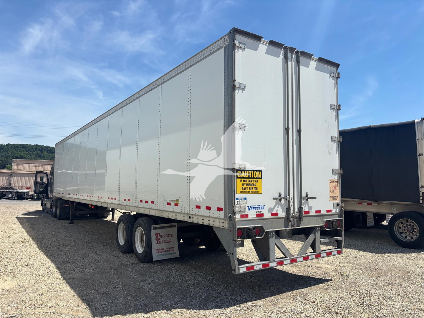Trailer box showing rear doors and Vanguard logo; aluminum trailer with dual rear doors, reflective tape, and safety decals.