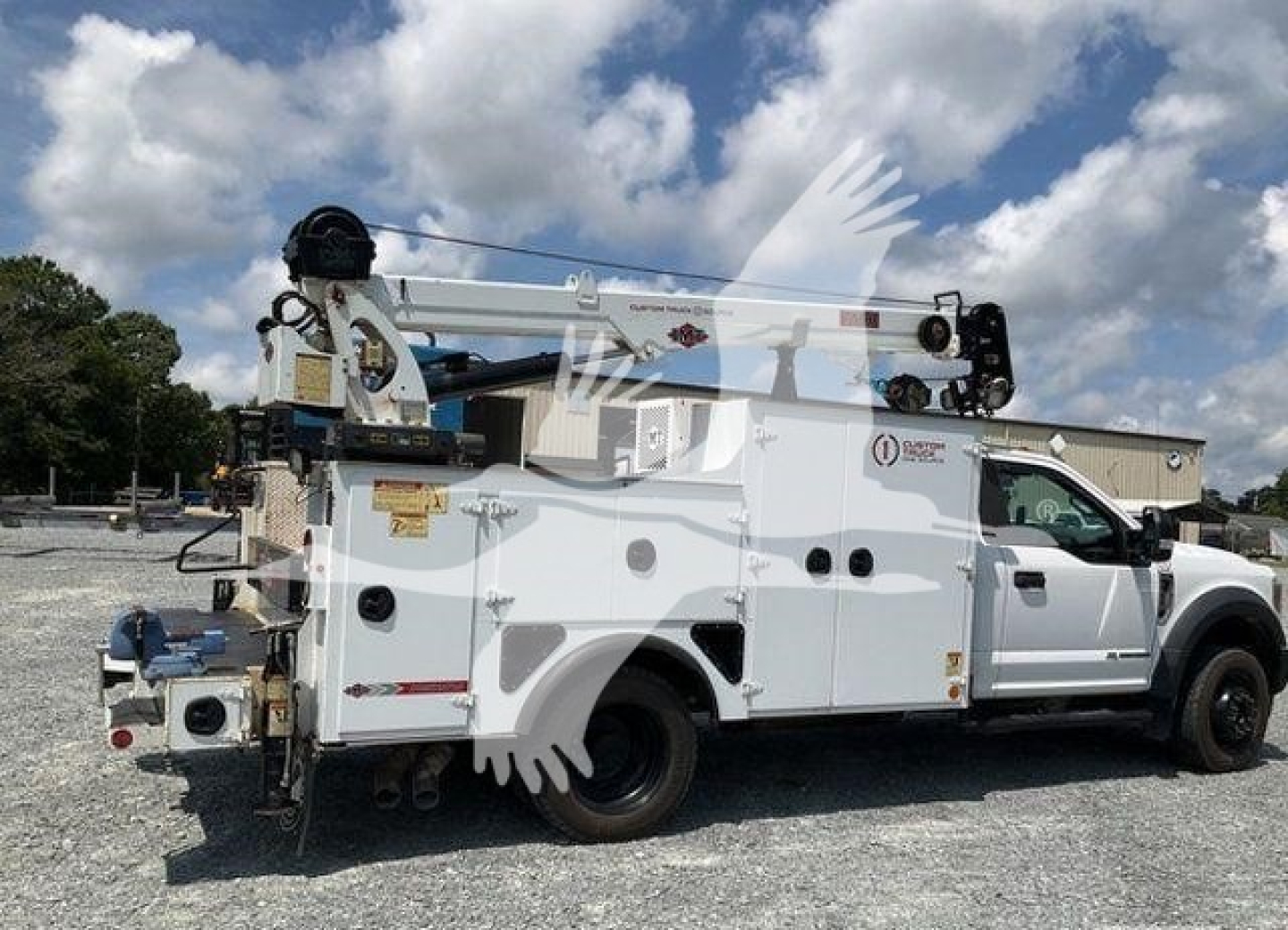 Ford F-550 utility service truck side view showing crane boom and storage compartments.