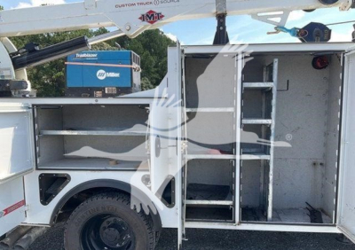 Ford F-550 utility truck side cabinet with open compartments and ladder rack