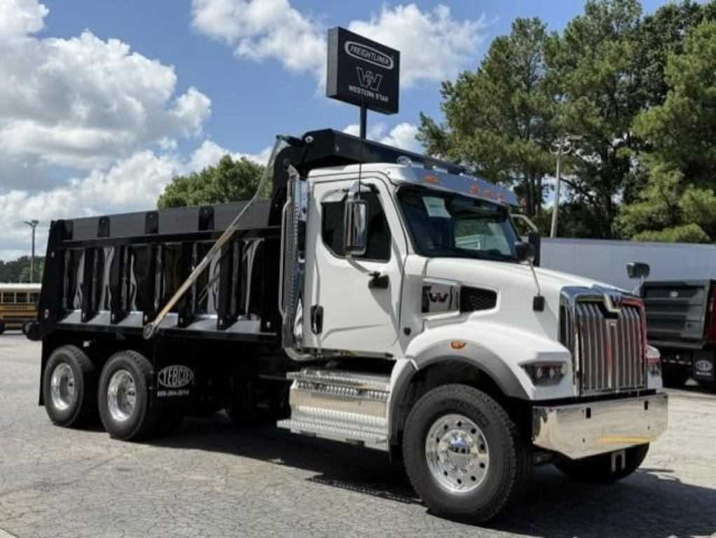 Western Star 47X dump truck in white cab with black dump bed and chrome accents, side view, under clear sky.