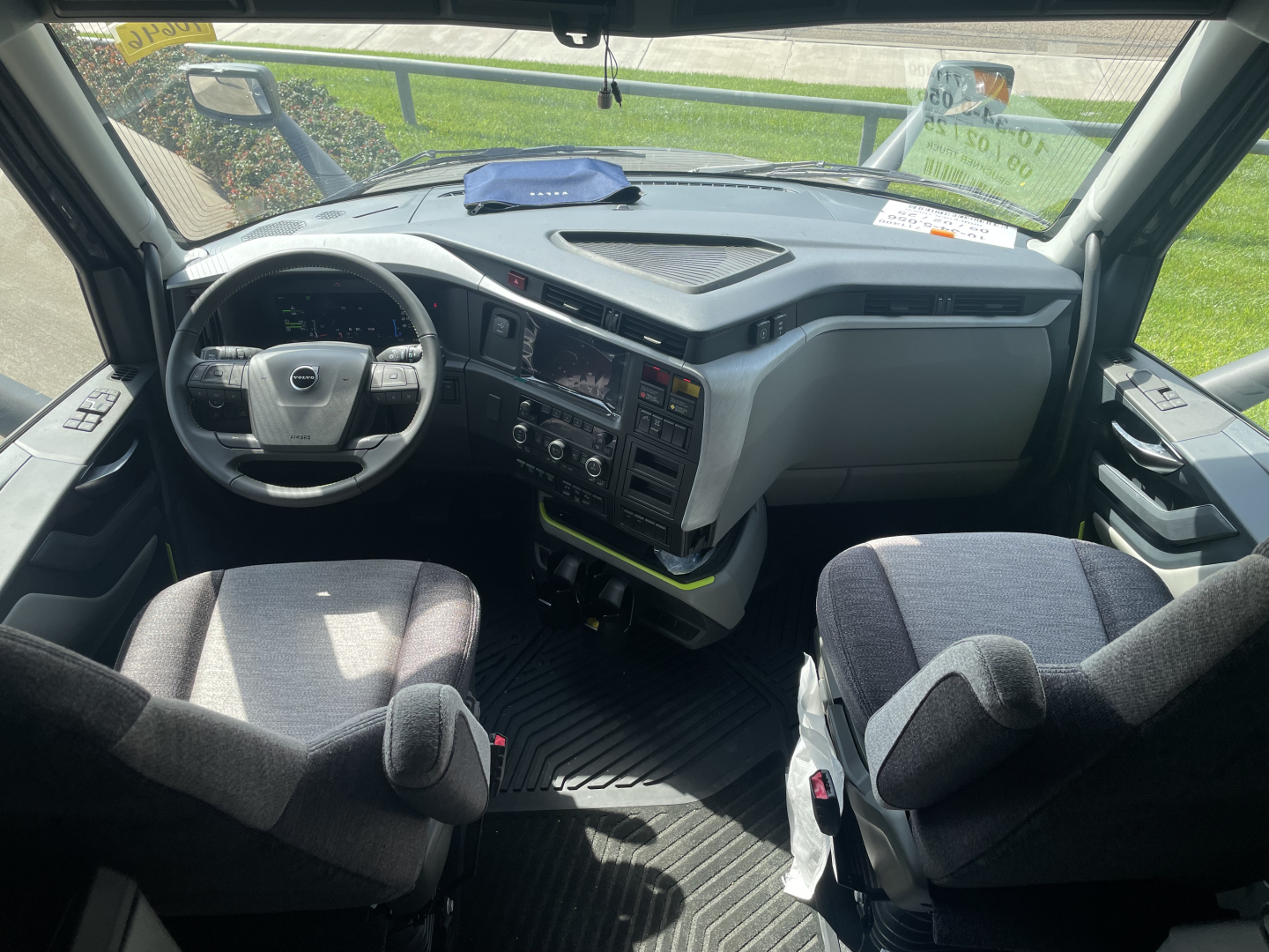 Cab interior of a 2026 Volvo VNL64T660 tractor showing steering wheel, dashboard, and two front seats in a sleeper cab.