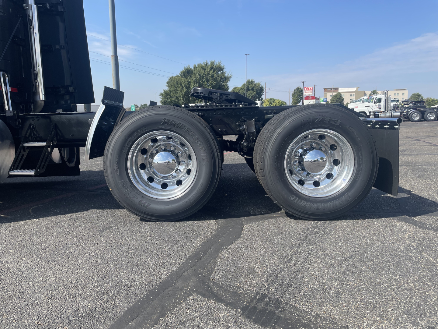 Side view of a Volvo truck chassis showing dual rear axles with polished wheels and black undercarriage.