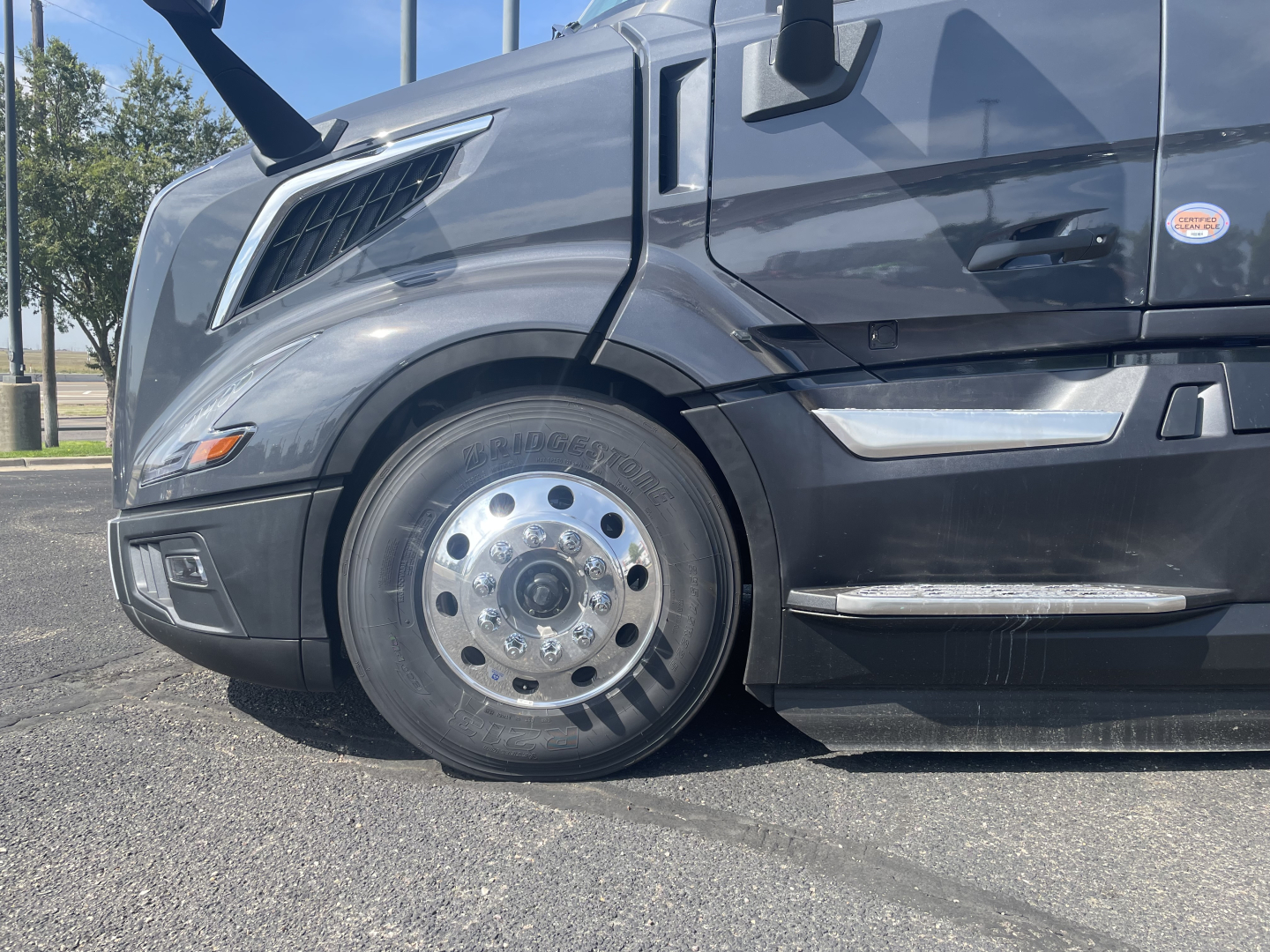 Volvo VNL64T660 truck front wheel and cab side showing chrome trim and wheel with polished hubcap.