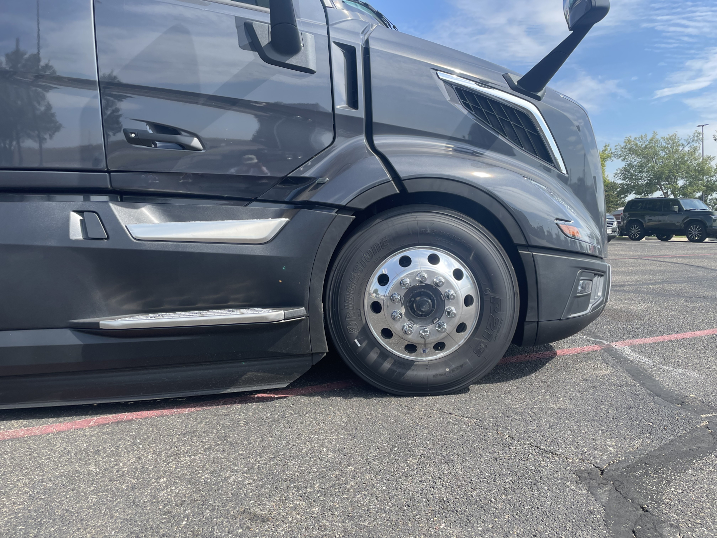 Volvo VNL64T660 truck front wheel view showing front fender and chrome hubcap