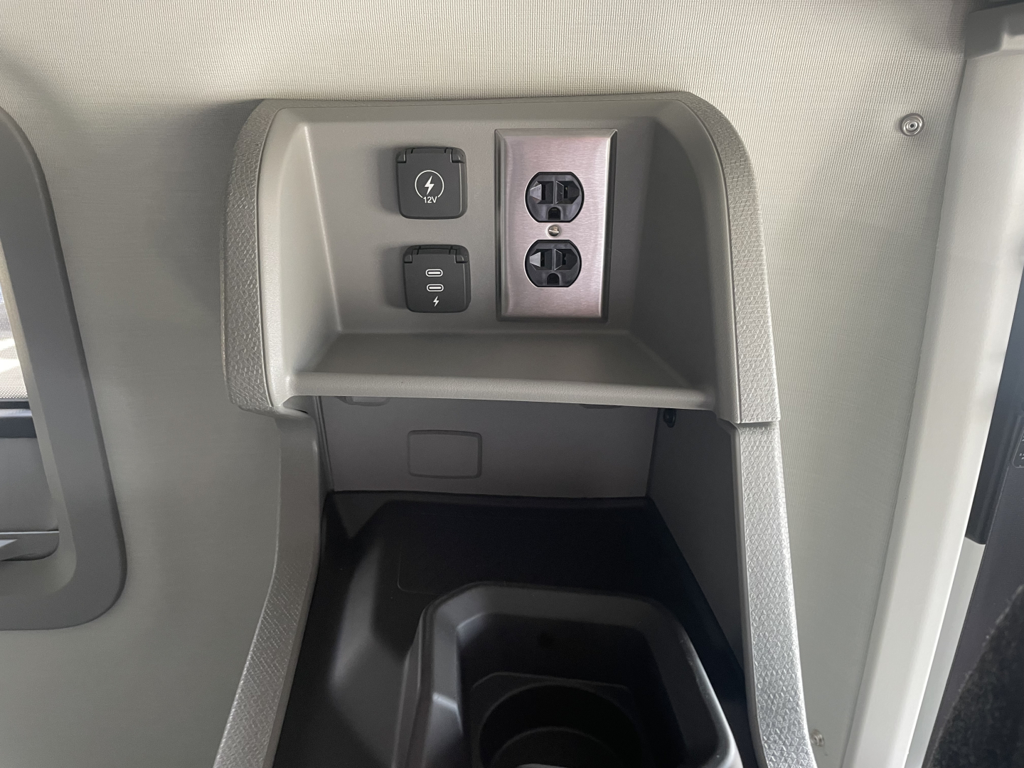 Truck interior center console with power outlet and two USB-style sockets, small cubby, and control switches visible.