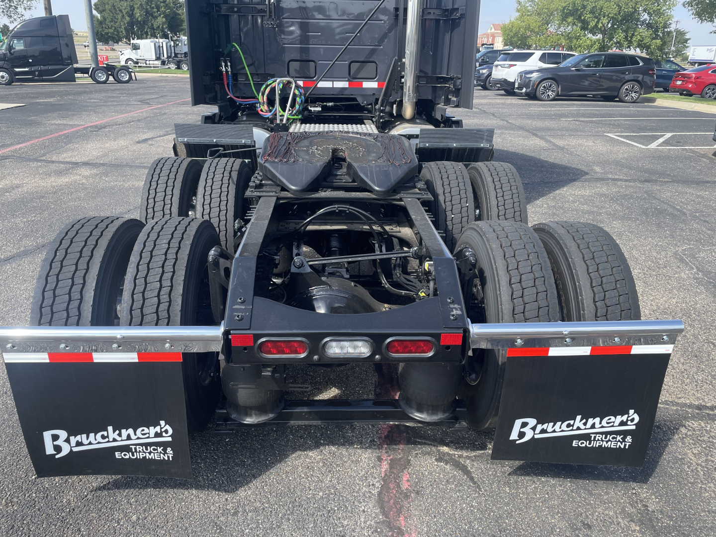 Volvo VNL truck rear view showing dual rear axles and Bruckner's mud flaps with truck equipment branding.