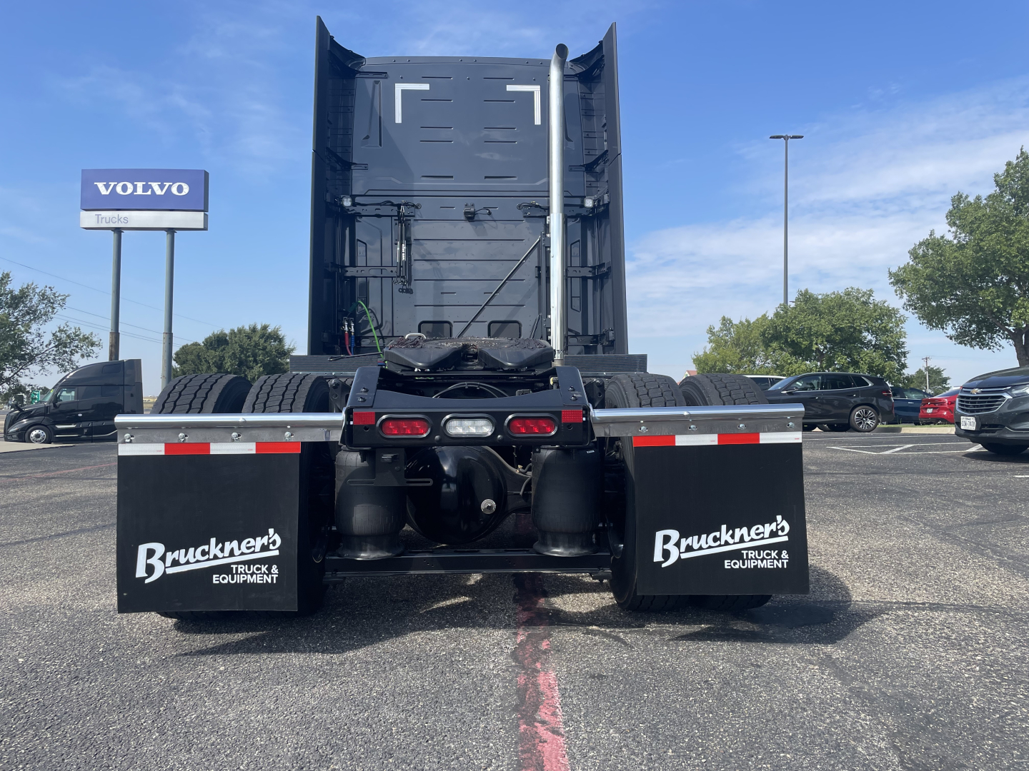 Rear view of a new Volvo VNL64T660 sleeper tractor showing fifth wheel, twin rear axles, and mudflaps with Bruckner’s Truck & Equipment branding.