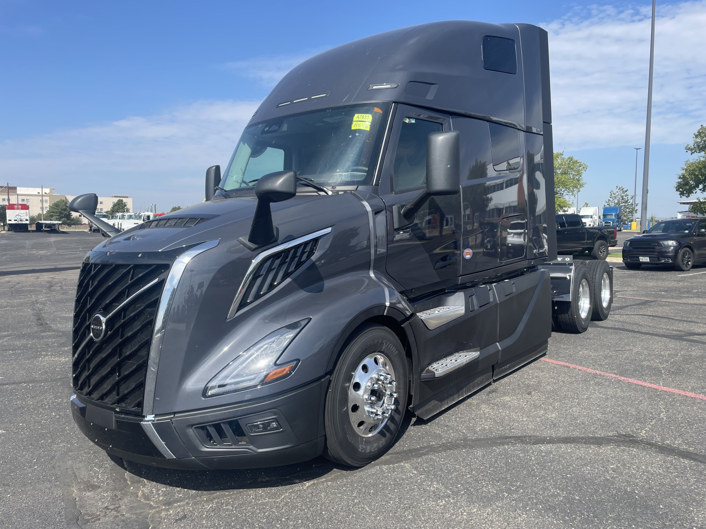 Volvo VNL64T660 truck in a parking lot, front-left angle showing the grille, headlights, and large sleeper cab.