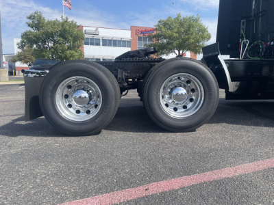 Volvo VNL64T660 tractor (front left view) showing dual rear drive wheels with polished chrome hubs and part of the cab chassis.