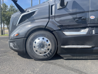 Volvo VNL64T660 truck front wheel and cab side showing chrome trim and wheel with polished hubcap.