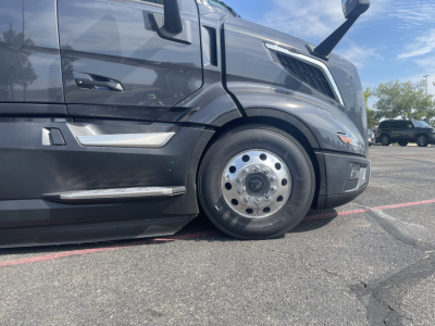 Volvo VNL64T660 truck front wheel view showing front fender and chrome hubcap