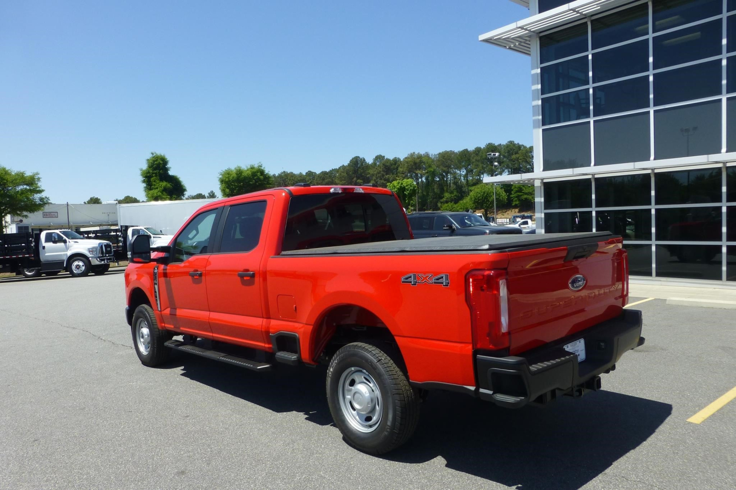 Ford F-250 pickup truck with 4x4 badge in red, rear three-quarter view showing bed and tailgate.