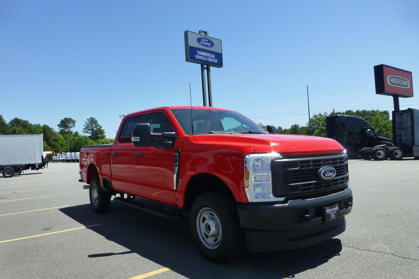 Red Ford F-250 pickup truck in a dealership lot, front-left view, with Ford emblem and black grille.