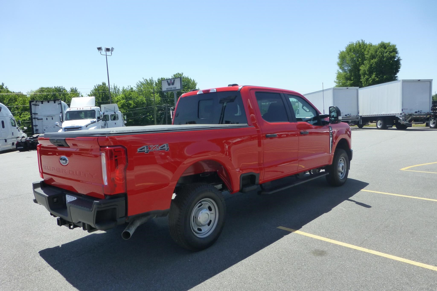 Red 2026 Ford F-250 Super Duty pickup truck 4x4 tailgate rear view in a dealership lot