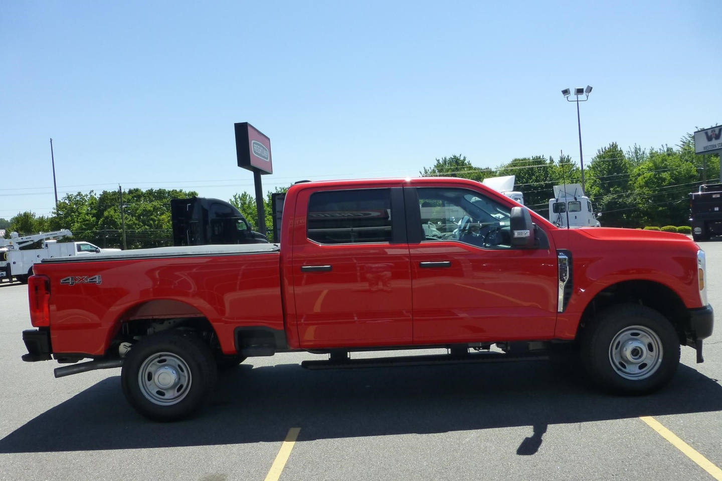 Ford F-250 Super Duty pickup truck side view showing extended cab, red paint, 4x4 badge, and dual rear wheels.