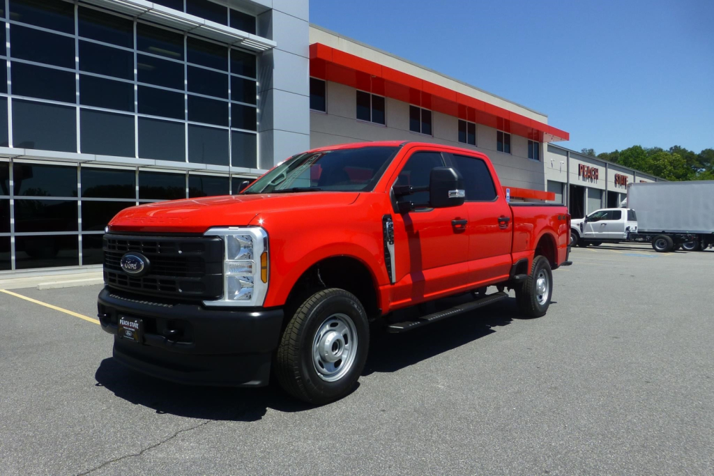 2026 Ford F-250 Super Duty pickup truck in red, front-side view, in dealership lot.