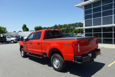 Ford F-250 pickup truck with 4x4 badge in red, rear three-quarter view showing bed and tailgate.