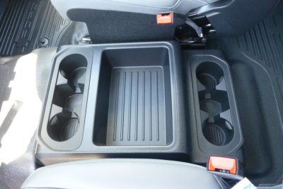 Truck interior center console with cup holders and storage bin in a Ford F-250 Super Duty crew cab.