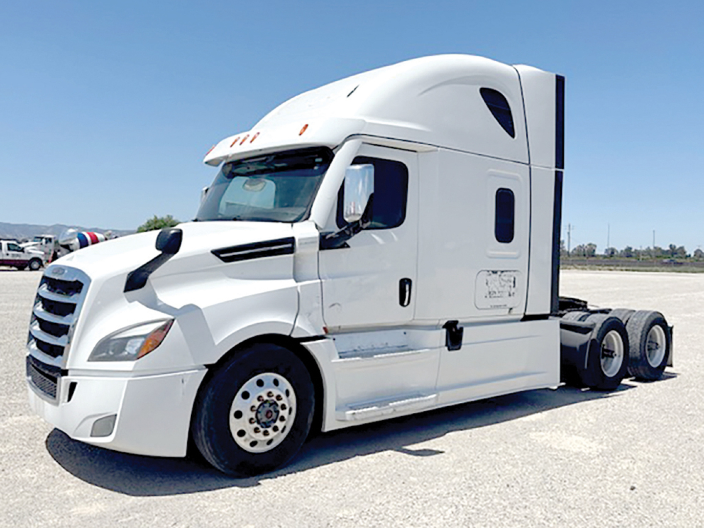 Truck cab showing front left side of a white 2022 Freightliner Cascadia126 tractor with sleeper, no trailer attached.