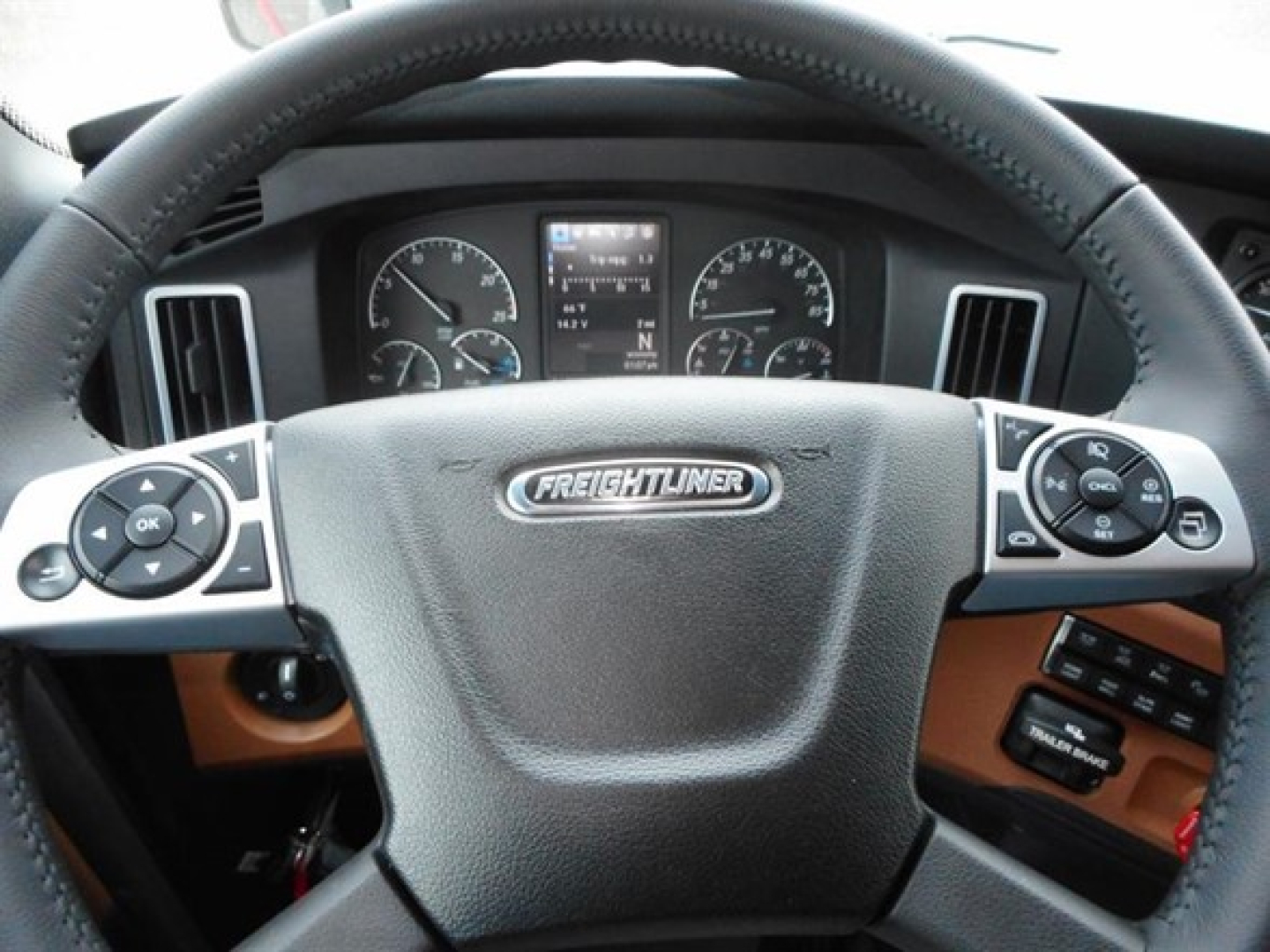 Dashboard view of a new 2027 Freightliner Cascadia 126 steering wheel with Freightliner emblem, and instrument cluster visible.