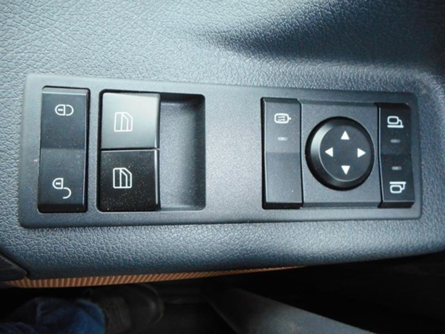 Truck interior window/side control panel showing multiple switch buttons and a circular control pad.
