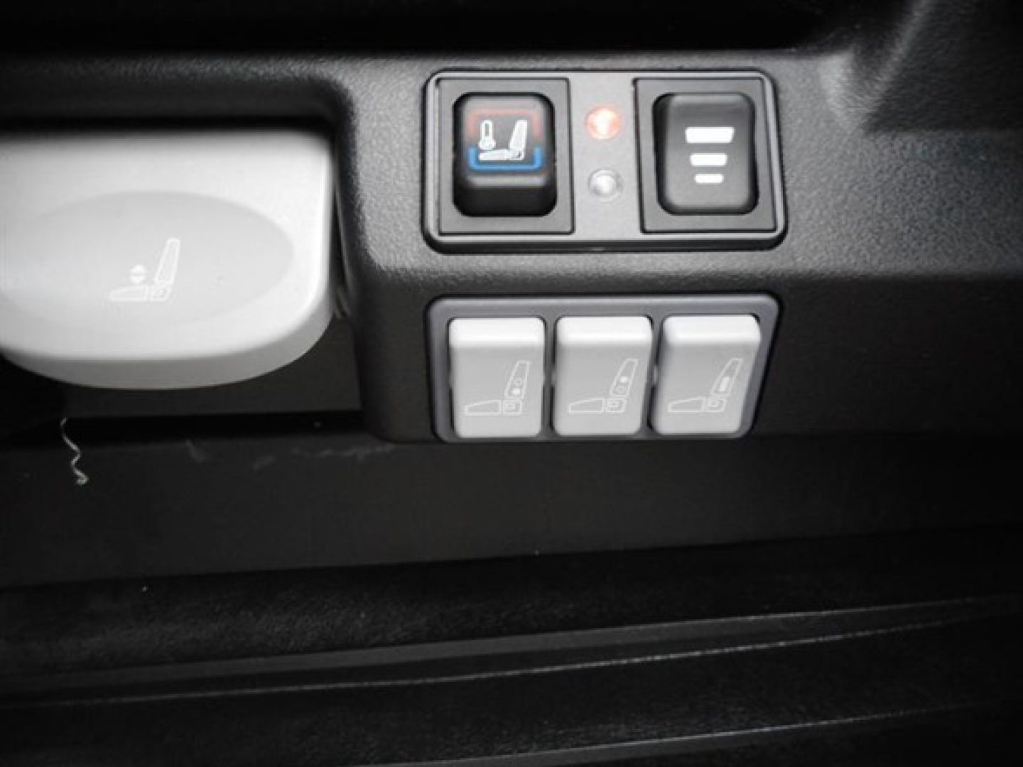 Freightliner Cascadia interior switches showing seat heater and control buttons with three seat icons and a seat heat indicator.