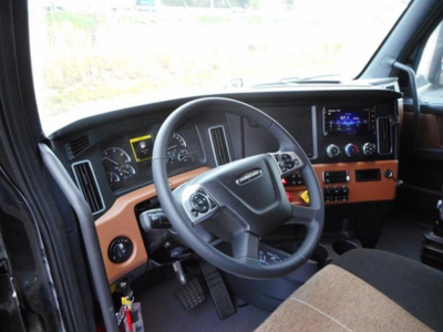Freightliner Cascadia 126 interior showing steering wheel, dashboard, and center console with digital display.