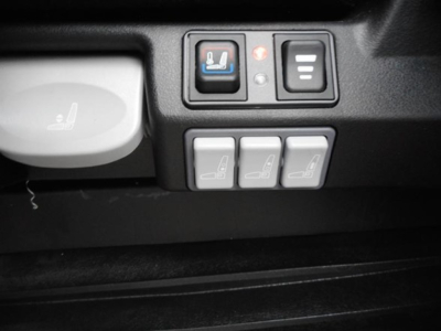 Freightliner Cascadia interior switches showing seat heater and control buttons with three seat icons and a seat heat indicator.
