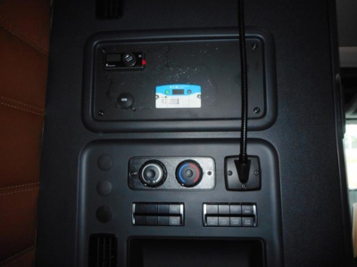 Cab interior view showing control panel with USB ports, climate controls, and a power/inverter area; part of Freightliner Cascadia interior.