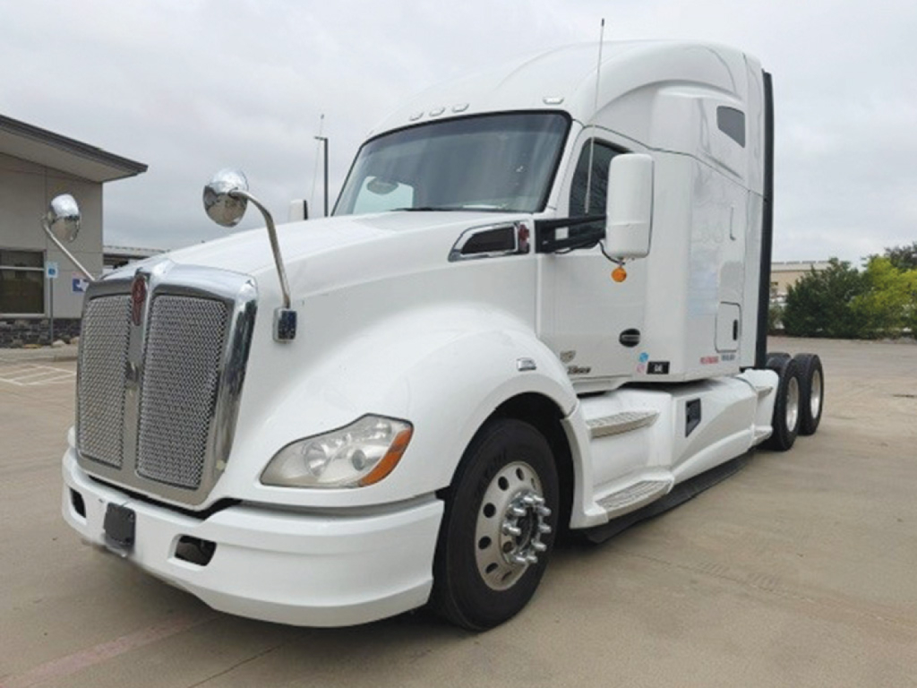 Kenworth T680 tractor-trailer front-left view showing large grille and white exterior with sleeper cab.
