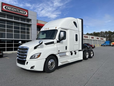 Freightliner Cascadia 126 tractor in white parked at dealership lot showing cab and front wheels.