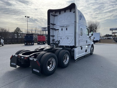 Freightliner Cascadia 126 sleeper cab tractor showing rear and side with dual rear axles and fifth wheel, white exterior, VIN plate not visible.