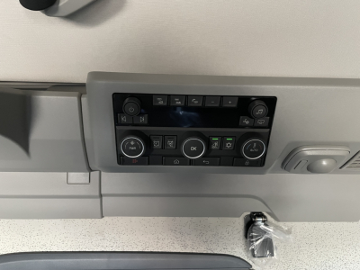 Volvo truck cab control panel with multiple buttons and knobs in view.