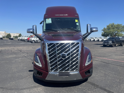 Front view of a maroon 2026 Volvo VNL64T860 cab-over truck showing large chrome grille and Volvo emblem.