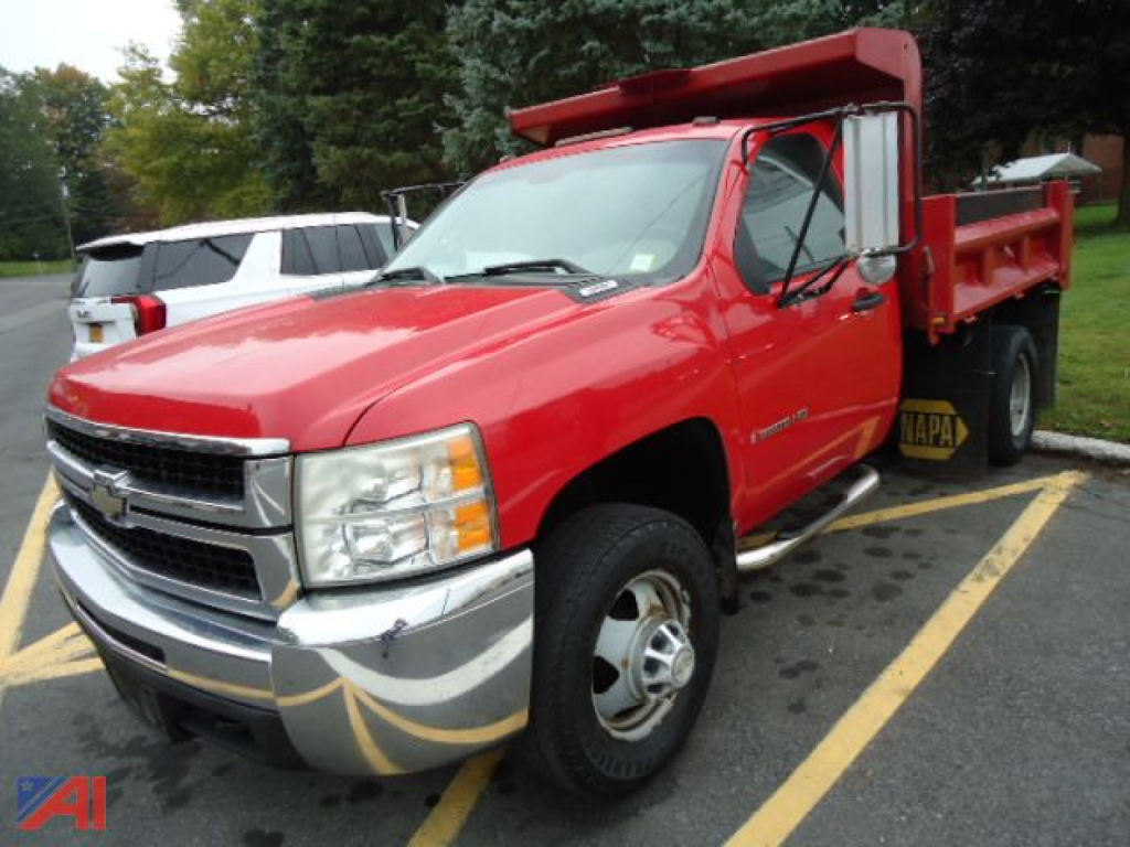 Chevrolet Silverado 1500/2500 style cab chassis pickup in red, front angled view, dump bed, Chrome bumper, VIN tag not visible.