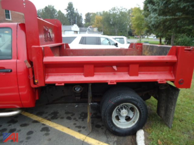 Chevrolet Silverado 1/2 Ton dump bed side view showing red dump truck bed and rear wheel, cab and chassis configuration.