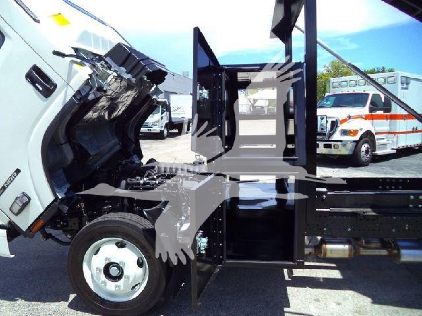 Isuzu NRR rollover truck with cab tilted forward showing engine area and side view of chassis and hydraulic components.