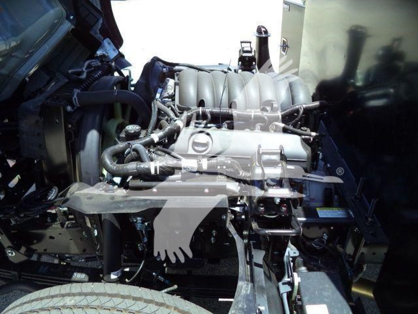 Isuzu NRR engine bay showing intake manifold and various hoses in view.