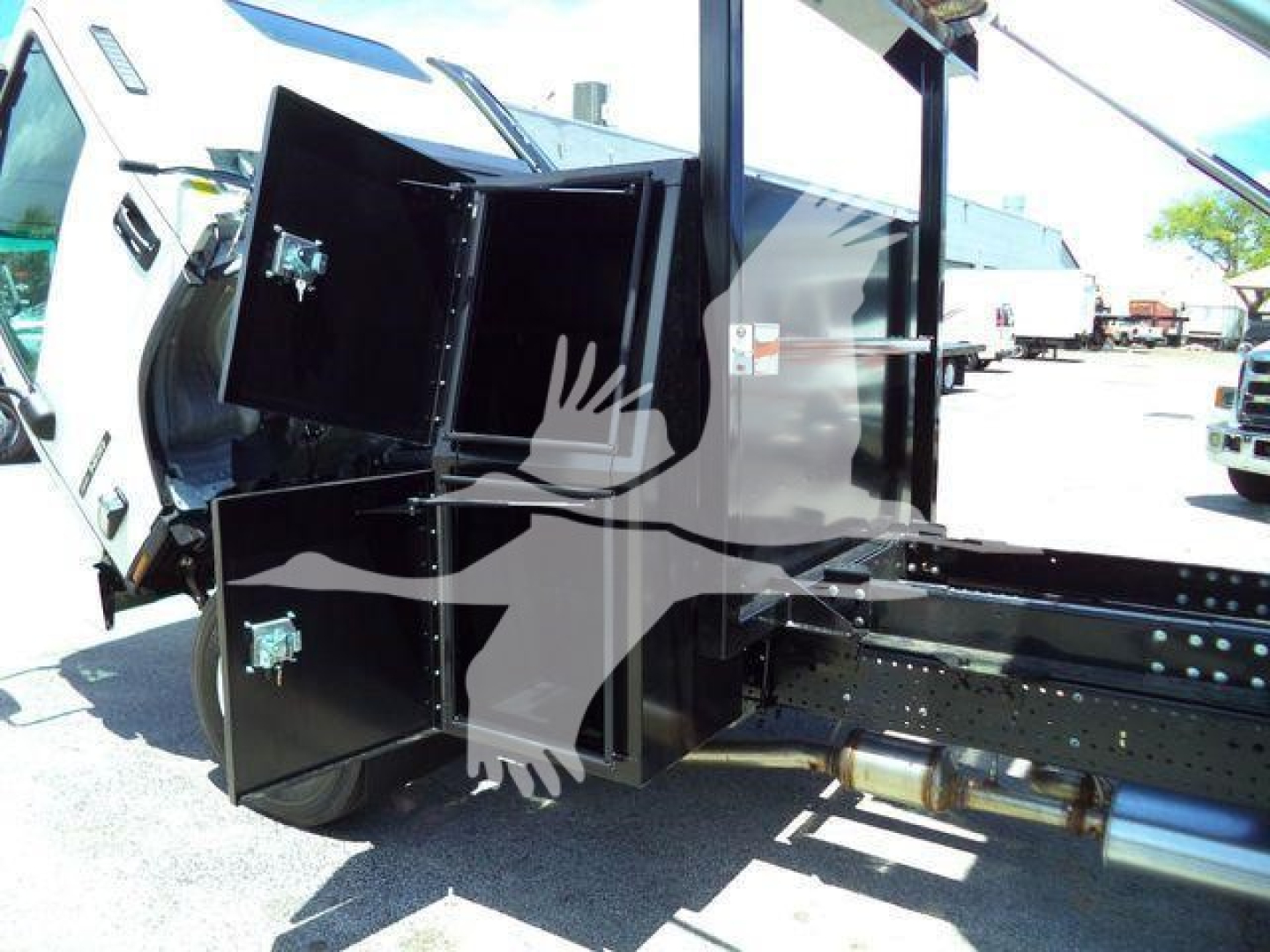 Isuzu NPRR rollover truck bed showing black storage cabinets with metal latches attached to chassis.
