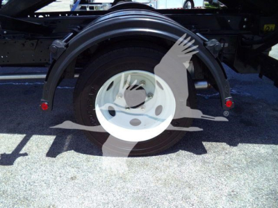 Truck rear wheel and fender of a 2024 Isuzu NPRR rolloff truck showing white steel wheel and black frame with red reflectors