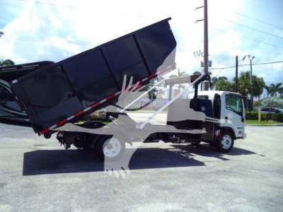 Isuzu NPRR dump truck in service position with raised dump bed, white cab and black truck bed, side view showing rear wheels and hydraulic mechanism.