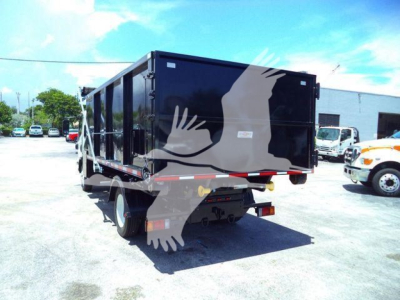 Isuzu NPRR truck in a lot, rear view showing black roll-off body and reflective rear bumper.