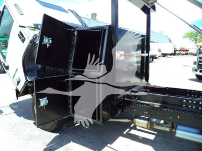Isuzu NPRR rollover truck bed showing black storage cabinets with metal latches attached to chassis.