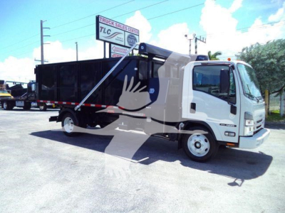 Isuzu NPR/NRR cab truck in a lot with a black dump body, side view showing front grille, windshield, and logo; no visible text on the vehicle exterior.
