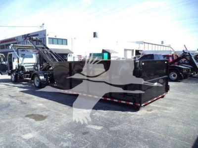 Isuzu NPR/NRR roll-off truck with large black dump bed in a dealership lot.
