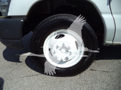 Ford E-450 wheel and front fender view showing steel wheel cover and tire. Visible text includes VIN 1FDXE4FS3BDA96309 on listing; stock number T96309.