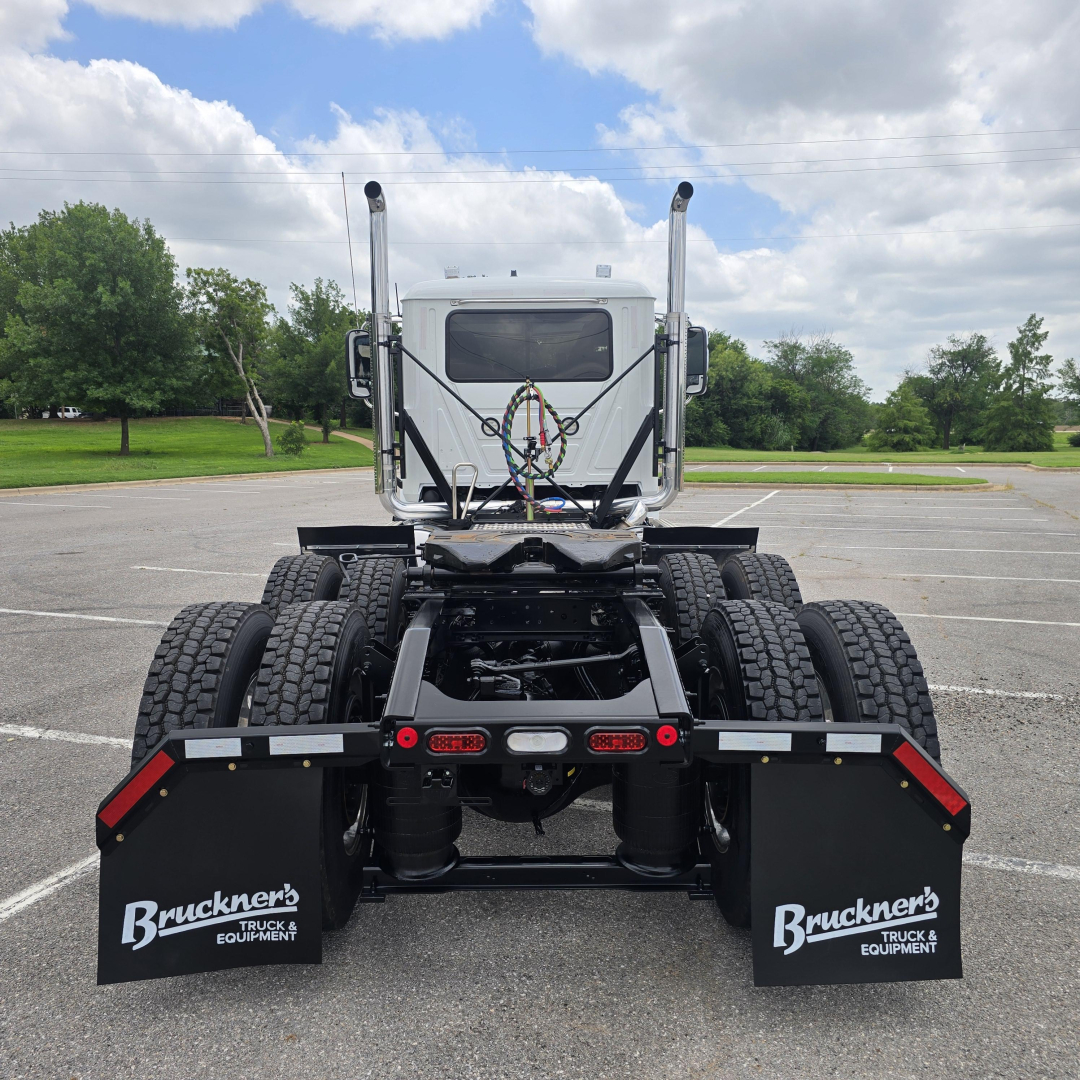 Mack PI64T truck cab rear view showing dual rear axles and fifth wheel with mudflaps labeled Bruckner's Truck & Equipment.